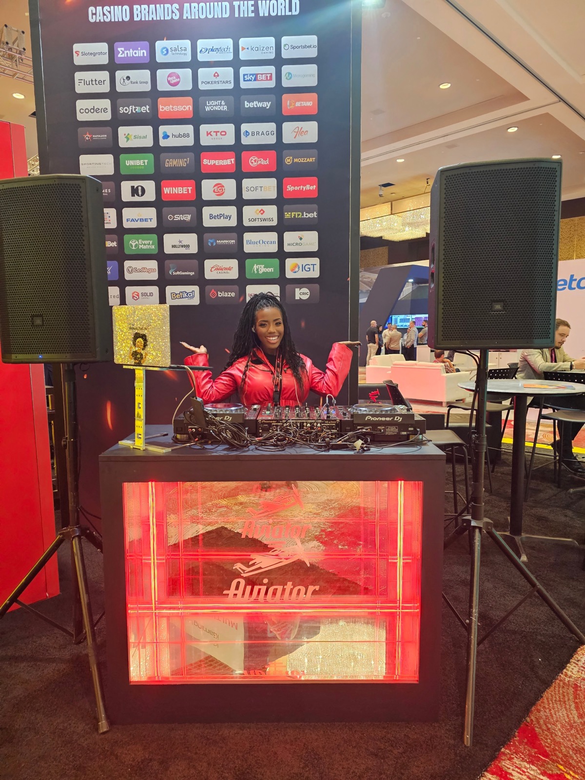 DJ ReRe at a branded corporate event with a sponsor wall
