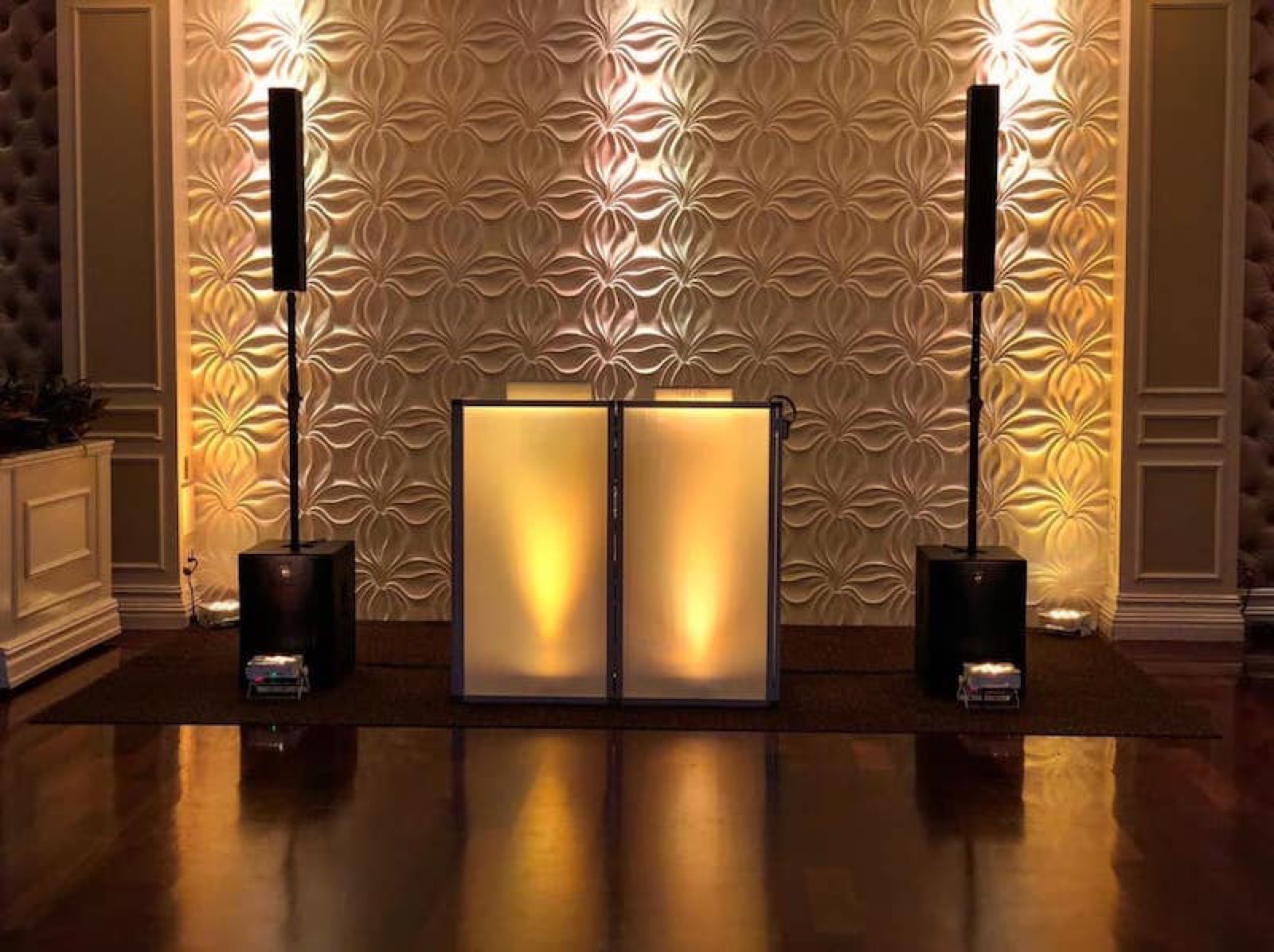 A glowing custom REmixed Events DJ booth and sound setup