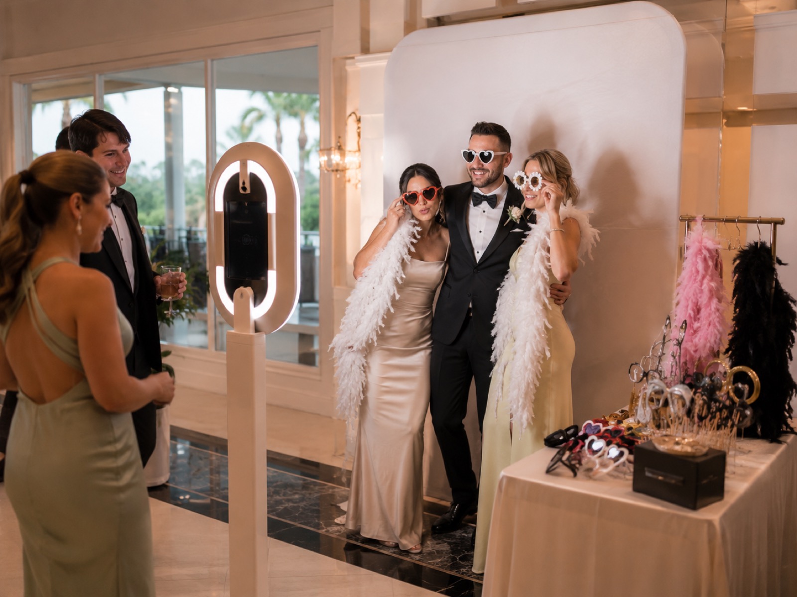 A couple posing at a wedding photo booth with props