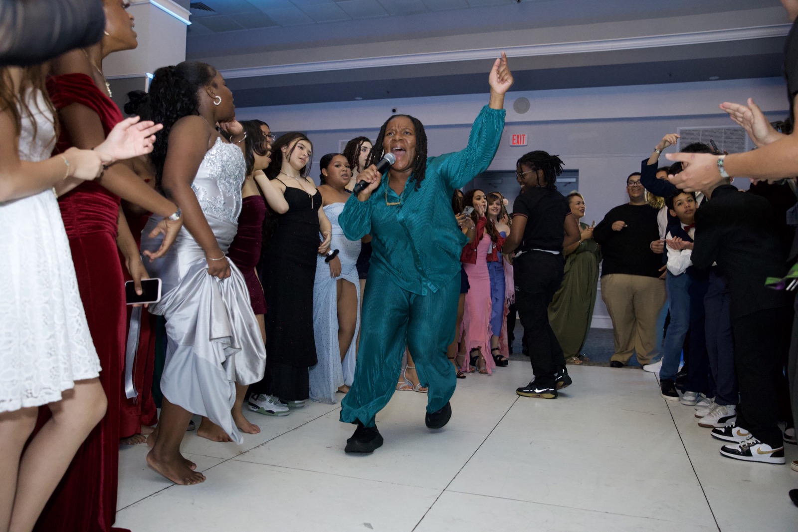 DJ IB hyping the crowd on the mic at a school dance