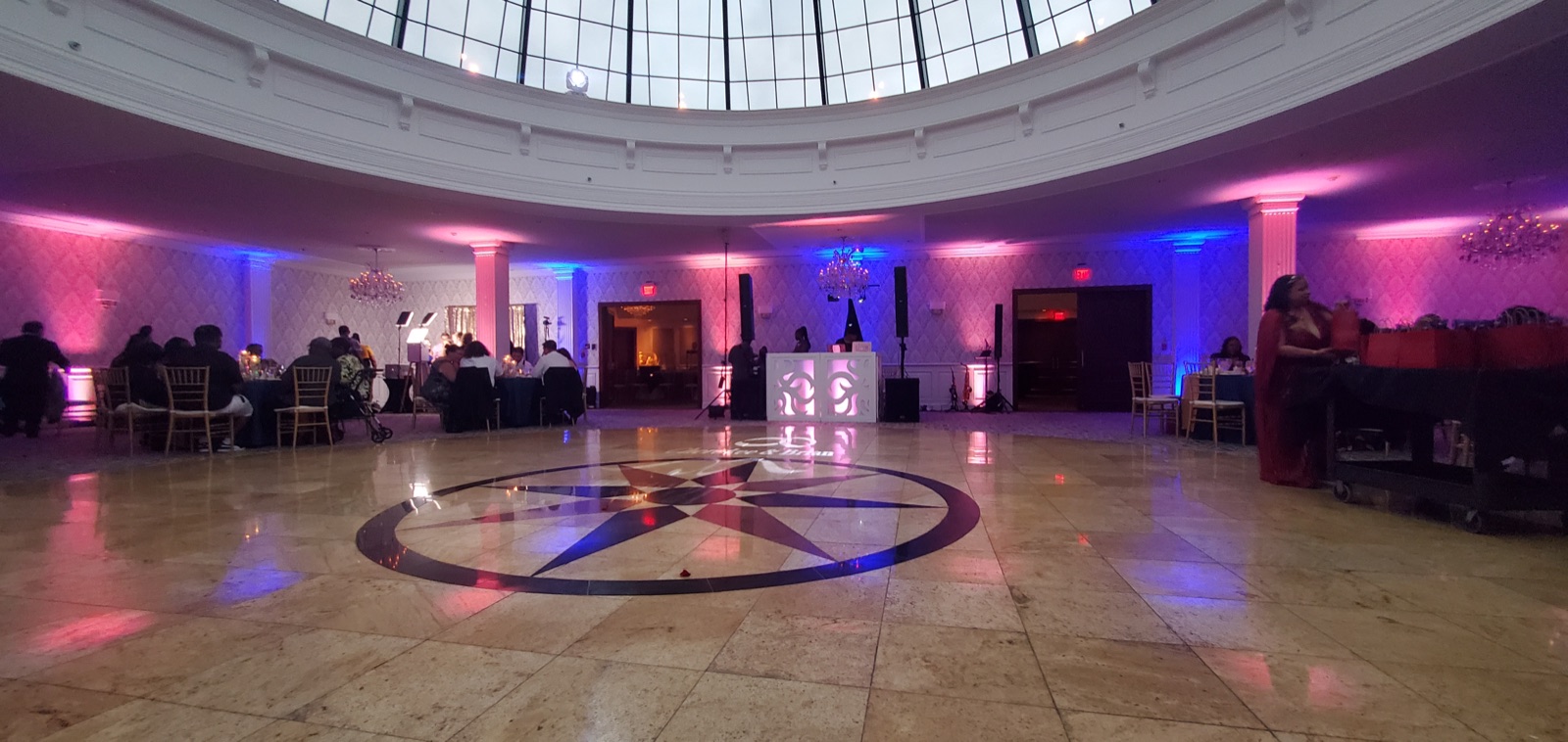 An elegant wedding ballroom transformed with uplighting and a monogram